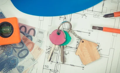 Kľúče, eurobankovky, náradie a stavebný plán ako symbol rozhodovania o cenovej ponuke pri rekonštrukcii bytového domu.