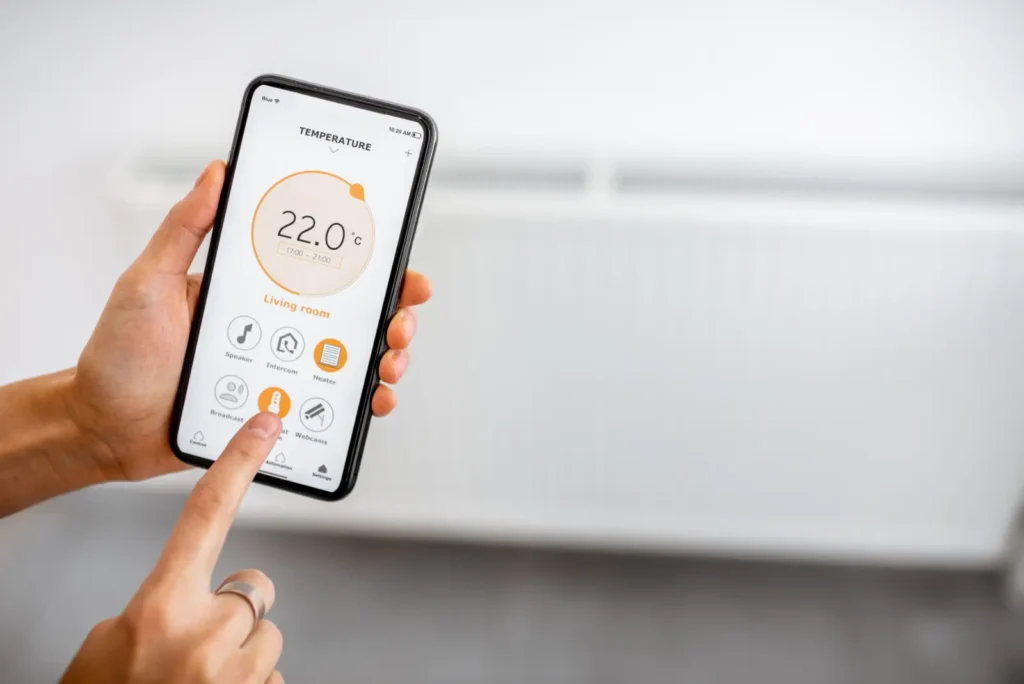 Ovládanie teploty cez smartfón ako symbol modernej regulácie kúrenia a energetickej efektivity v bytovom dome.